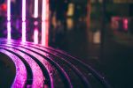 Close up of rain drops on a bench at night