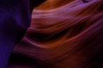 Interior of a rock formation bathed in orange and purple light
