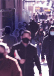 People walking in busy city street wearing face mask